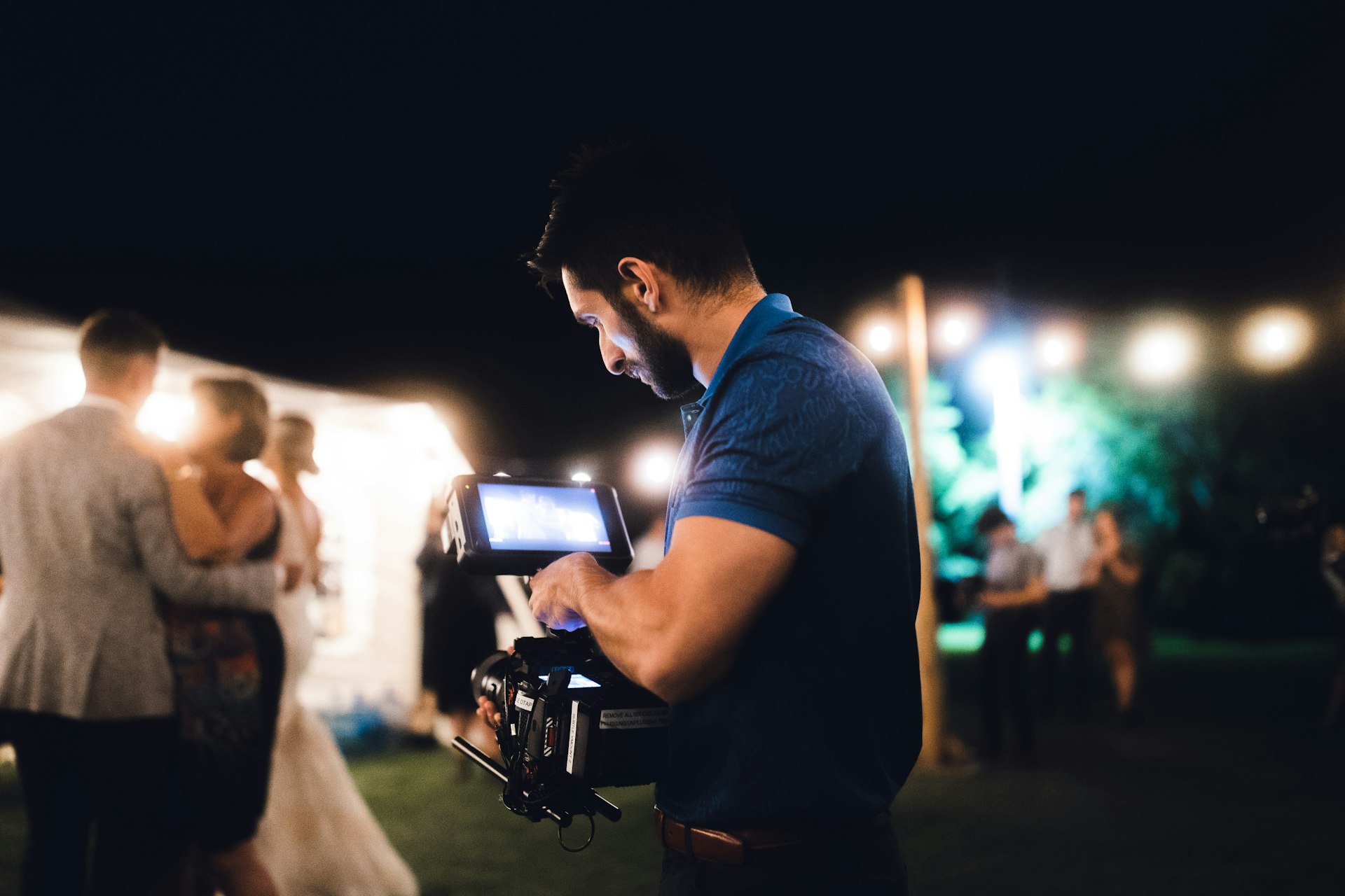 A man standing next to a woman holding a camera